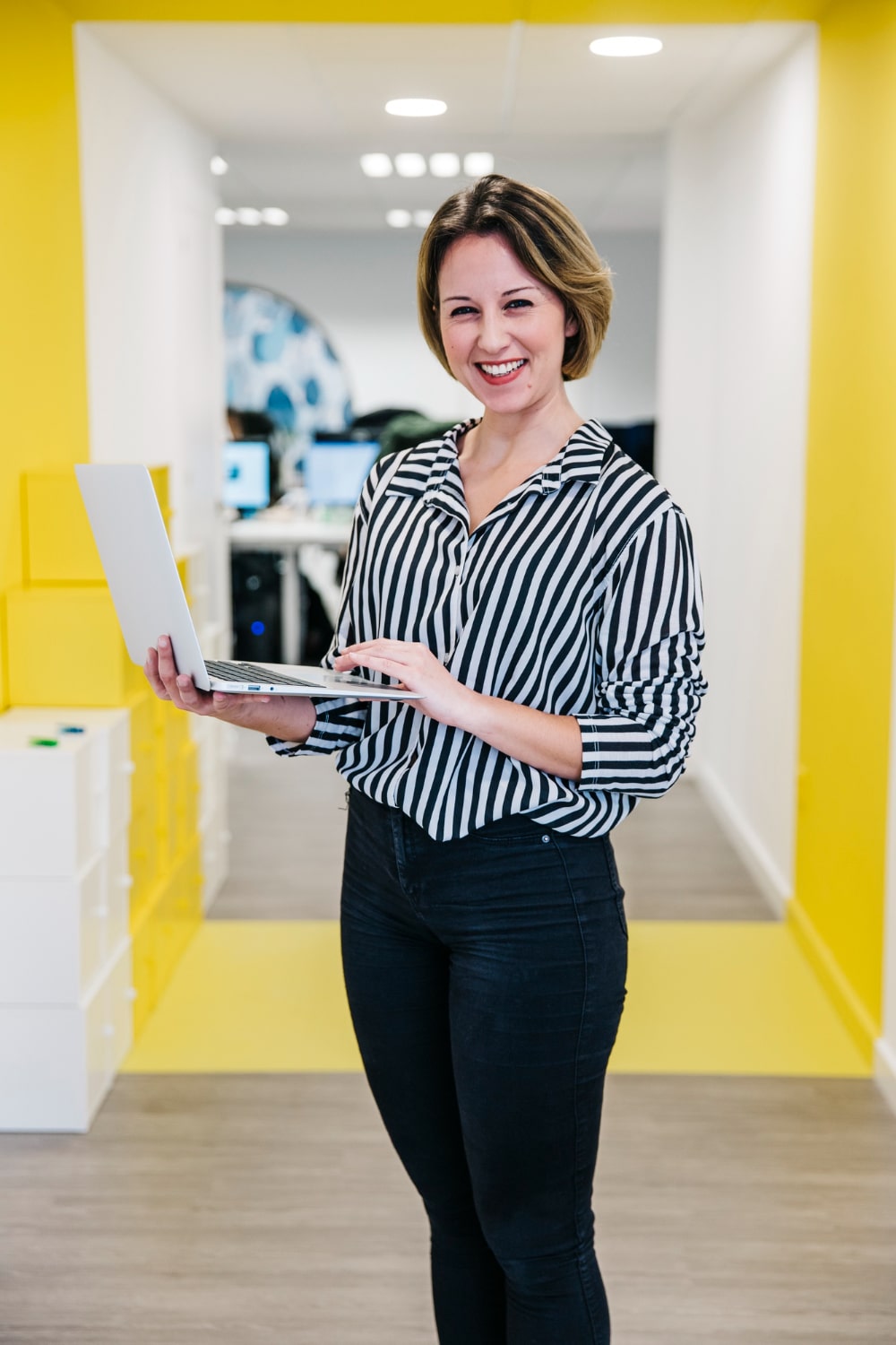 laughing-woman-with-laptop-office-min
