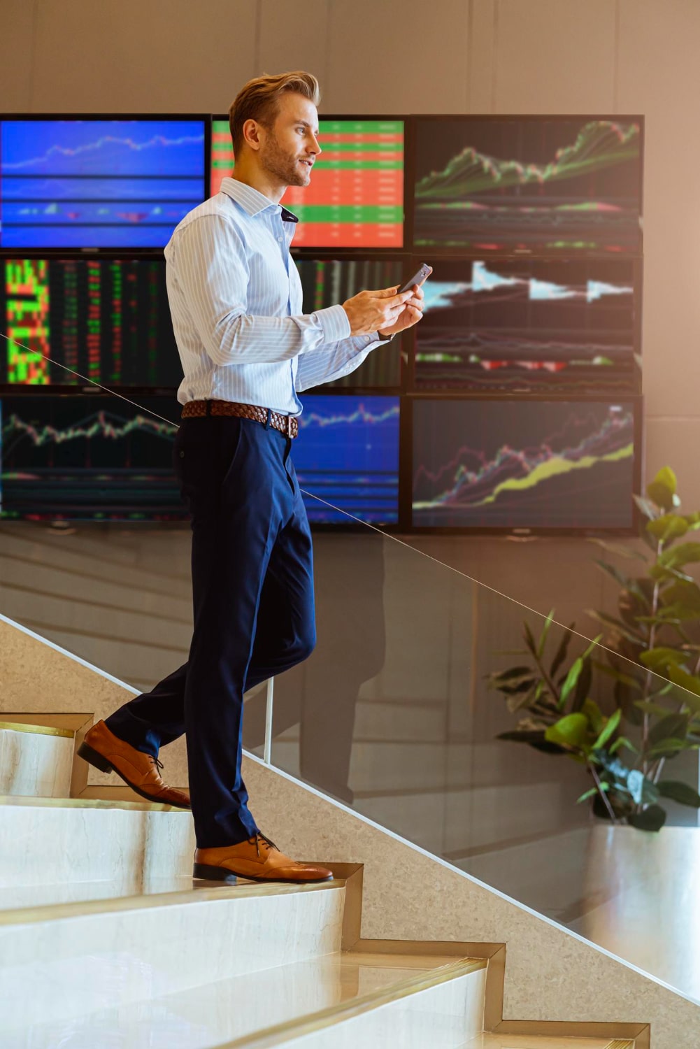 successful-smart-caucasian-businessman-walking-stair-trade-stock-with-smartphone-communicate-with-happiness-enthusiastic-modern-office-background-min
