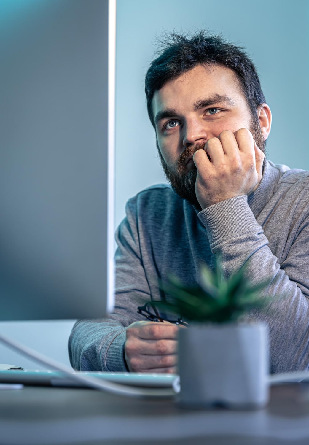 tired-bearded-man-looks-computer-screen-min