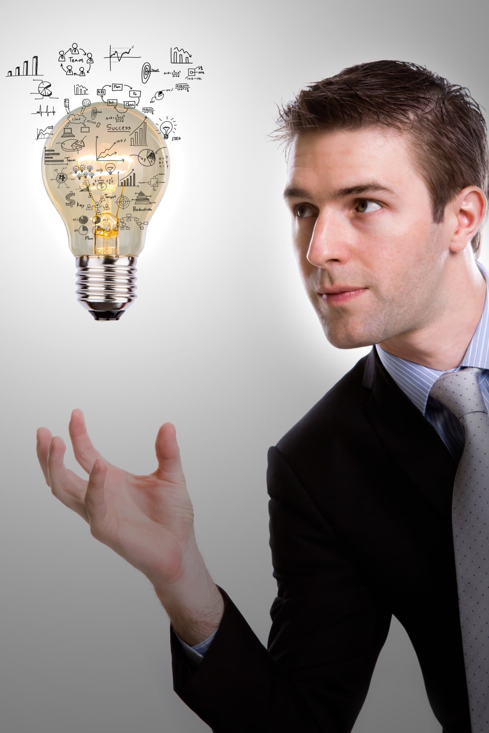 concentrated-businessman-looking-light-bulb-with-diagrams-min